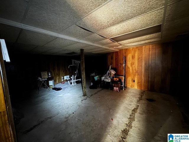 basement featuring wooden walls