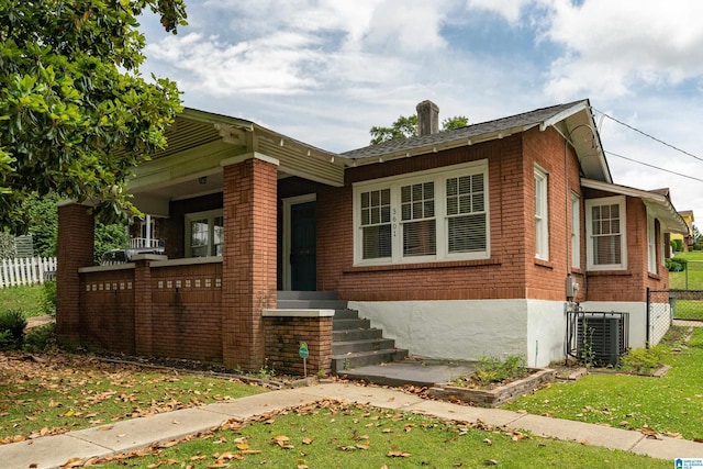 view of front of house featuring central AC unit and a front lawn