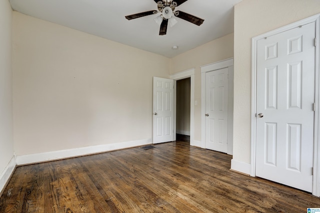 unfurnished bedroom with dark wood-type flooring and ceiling fan