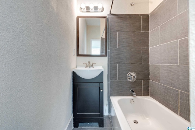 bathroom with tiled shower / bath and vanity