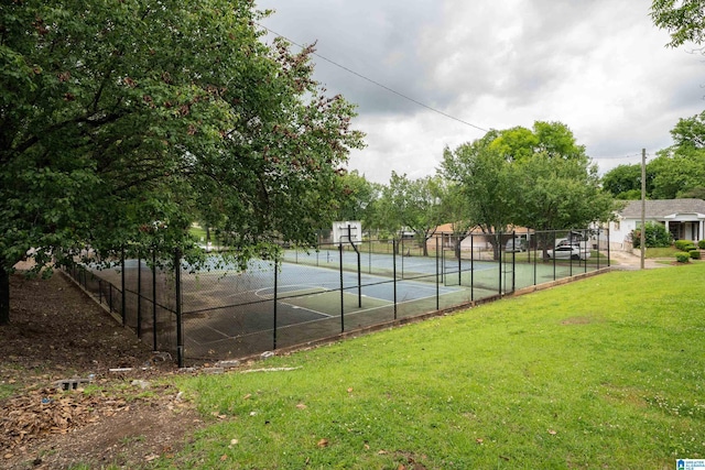 view of tennis court featuring a yard