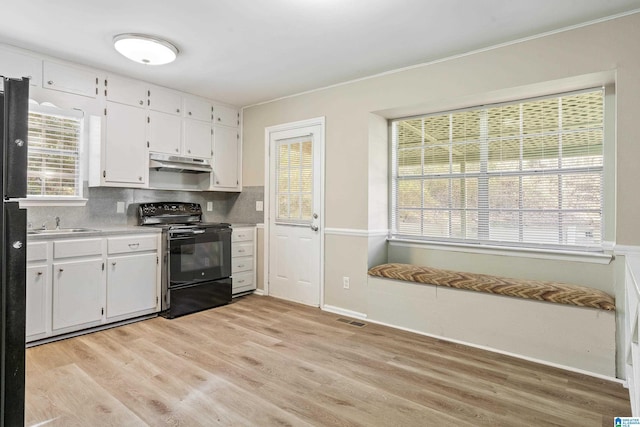 kitchen with white cabinets, decorative backsplash, light hardwood / wood-style floors, sink, and black electric range oven