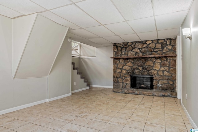 unfurnished living room with a drop ceiling and a fireplace