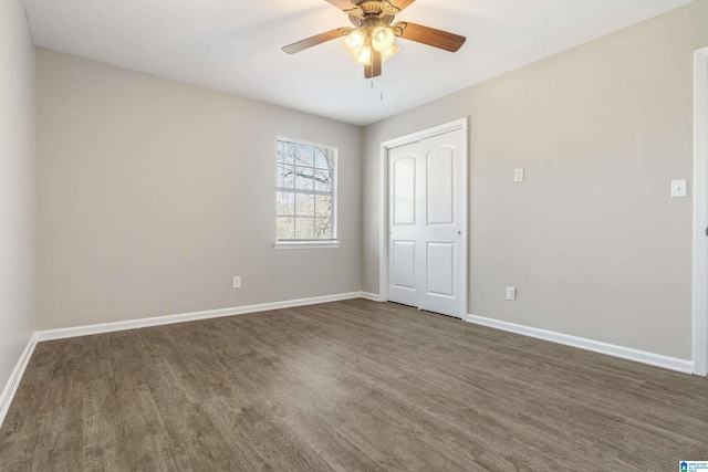 spare room featuring dark wood-type flooring and ceiling fan