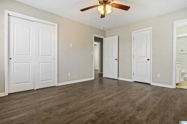 unfurnished bedroom featuring ensuite bathroom, ceiling fan, and dark wood-type flooring