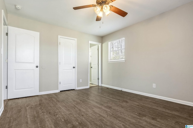 unfurnished bedroom featuring ceiling fan and dark wood-type flooring