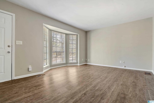 empty room with dark wood-type flooring