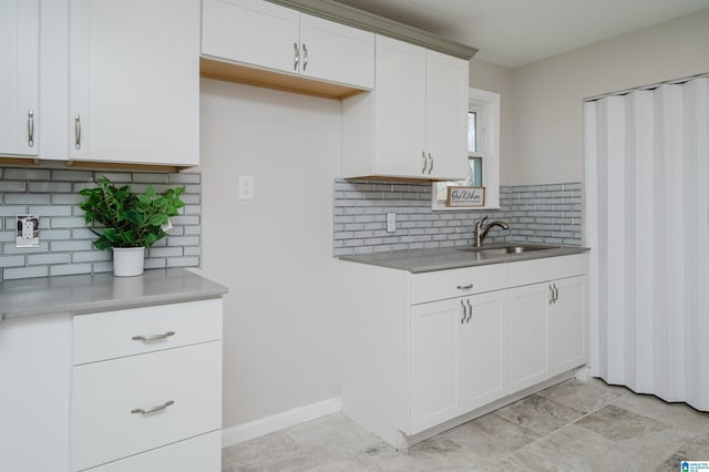 kitchen with sink, backsplash, and white cabinets