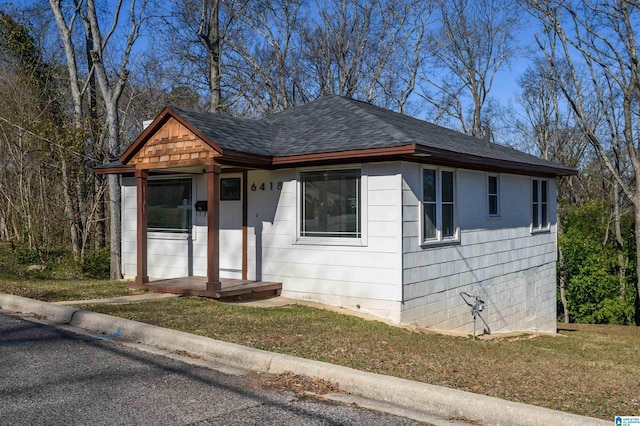 bungalow-style home with a front yard