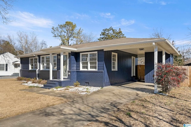 ranch-style house featuring a porch and a carport