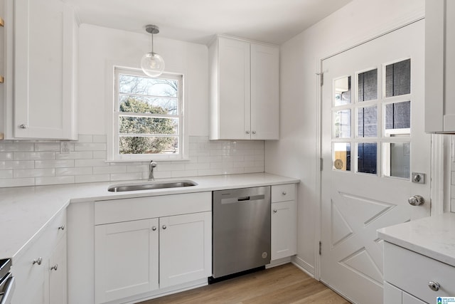 kitchen with pendant lighting, white cabinets, and dishwasher