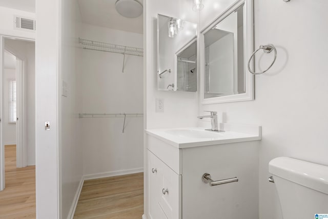 bathroom with wood-type flooring, toilet, and vanity