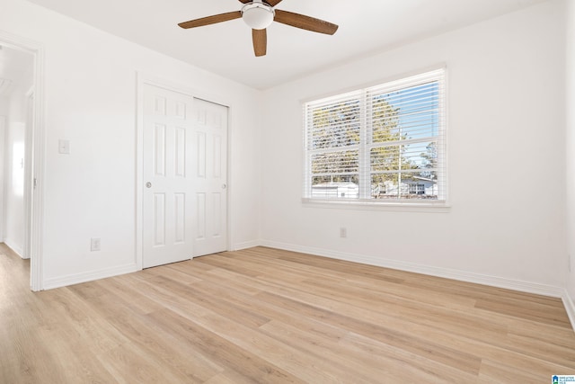 unfurnished bedroom featuring ceiling fan, a closet, and light hardwood / wood-style floors