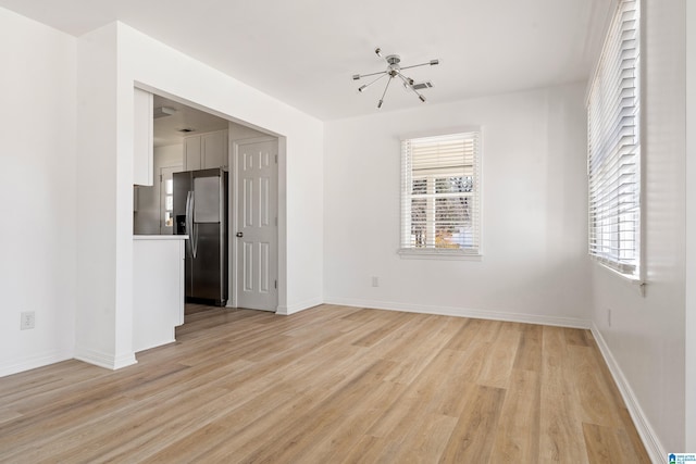 spare room with a healthy amount of sunlight and light hardwood / wood-style floors