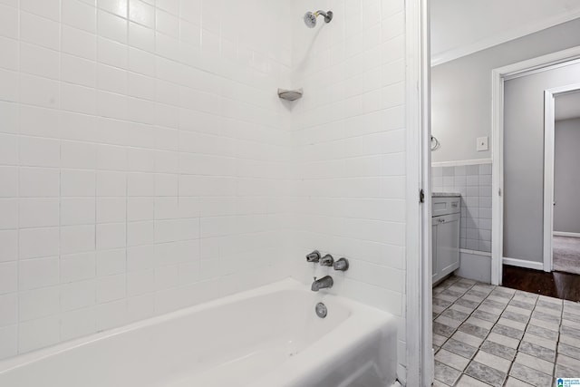 bathroom with tile walls, tiled shower / bath combo, and vanity