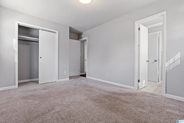 unfurnished bedroom featuring light colored carpet and a closet