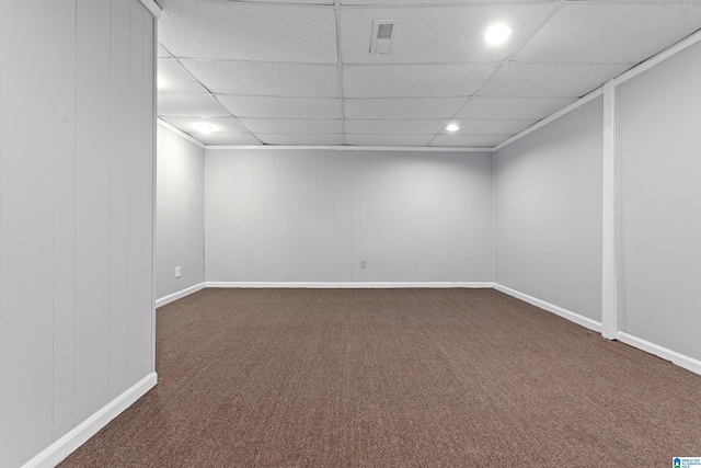 carpeted empty room featuring a drop ceiling