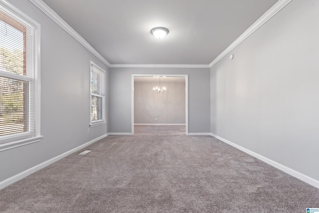 empty room featuring a chandelier, ornamental molding, and carpet flooring