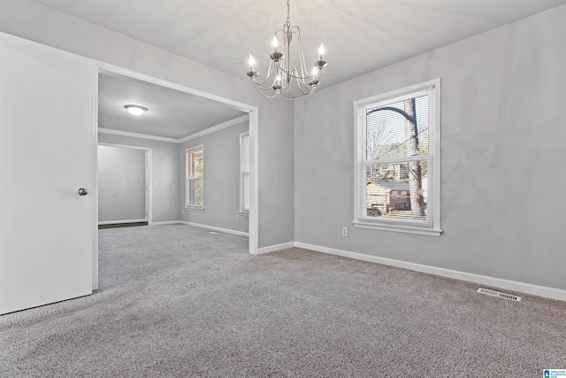 empty room featuring carpet floors, crown molding, and a chandelier