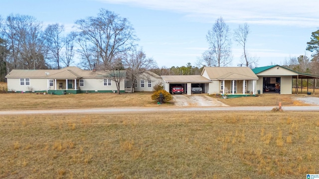 ranch-style house featuring a garage, a front lawn, a porch, and a carport