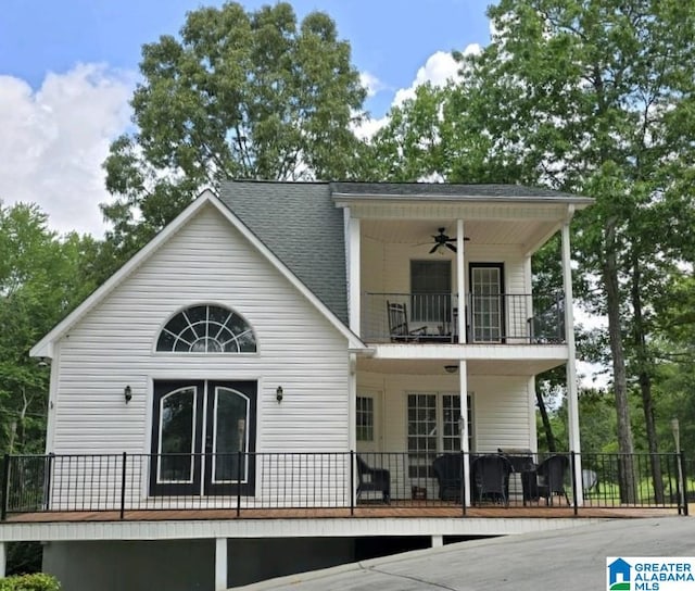 rear view of property with ceiling fan and a balcony