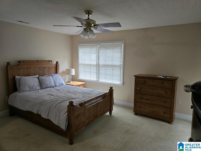 carpeted bedroom featuring ceiling fan and a textured ceiling