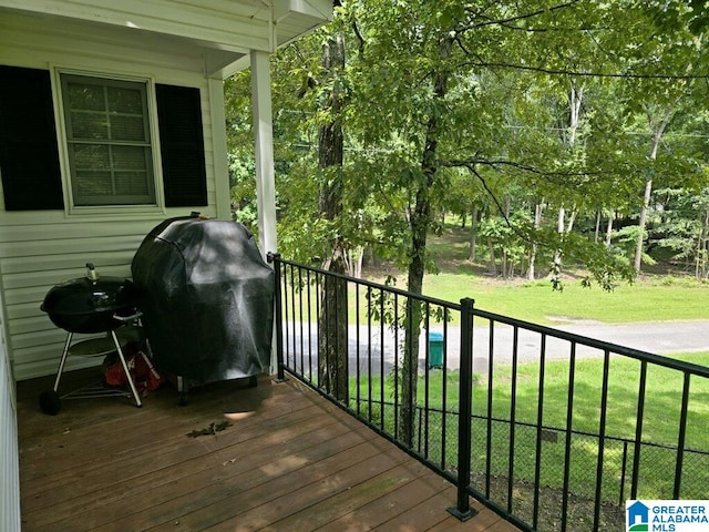 wooden deck with a grill and a yard