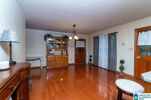 dining space featuring a notable chandelier, a textured ceiling, and hardwood / wood-style flooring