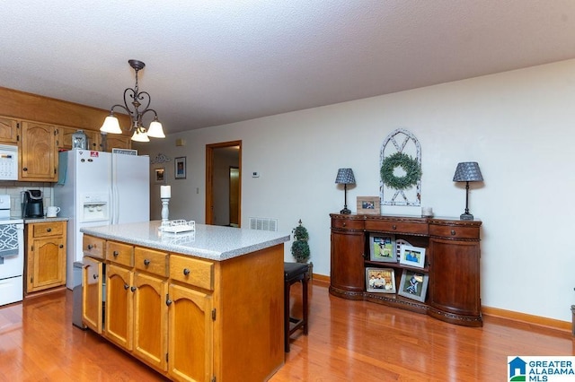 kitchen featuring tasteful backsplash, a notable chandelier, white appliances, hanging light fixtures, and a kitchen island