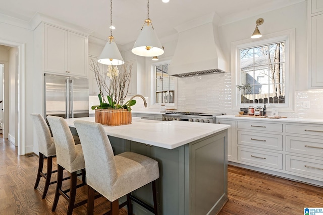 kitchen featuring white cabinetry, a kitchen island, custom range hood, and backsplash