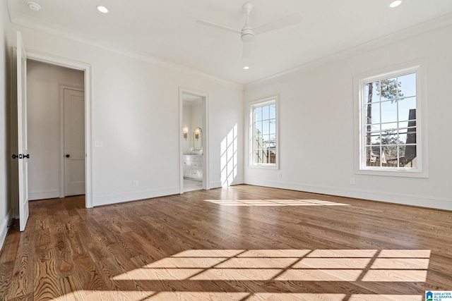 spare room with ceiling fan, crown molding, a wealth of natural light, and wood-type flooring