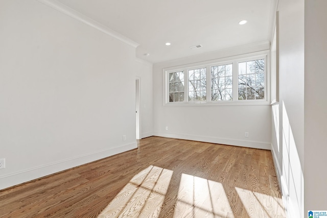 unfurnished room featuring crown molding and light wood-type flooring