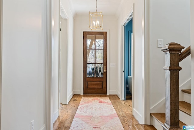 doorway with a chandelier and light hardwood / wood-style floors