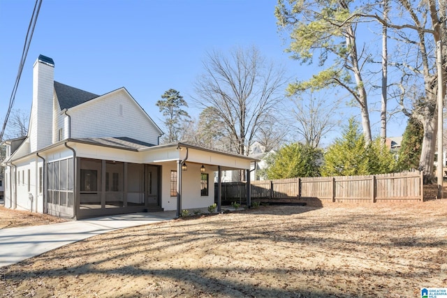 view of side of property featuring a carport and a sunroom