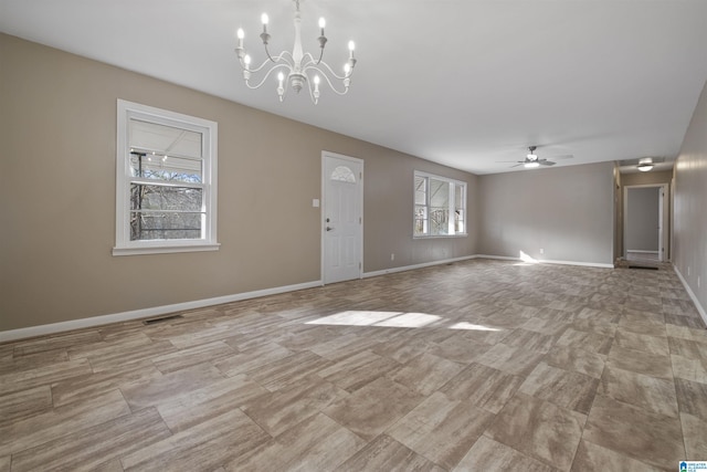 unfurnished living room with ceiling fan with notable chandelier