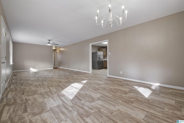 unfurnished living room featuring ceiling fan with notable chandelier