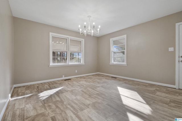 spare room featuring a chandelier