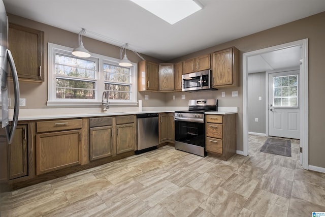 kitchen featuring decorative light fixtures, sink, plenty of natural light, and stainless steel appliances