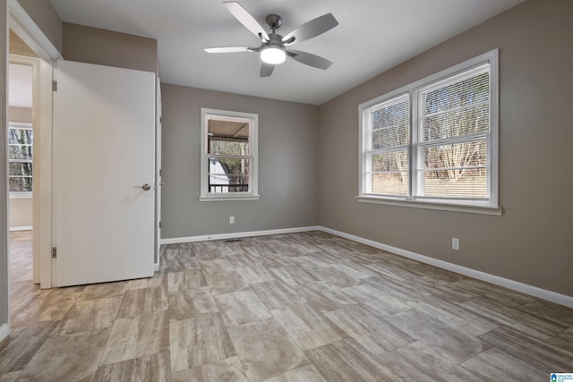 spare room with ceiling fan and a wealth of natural light