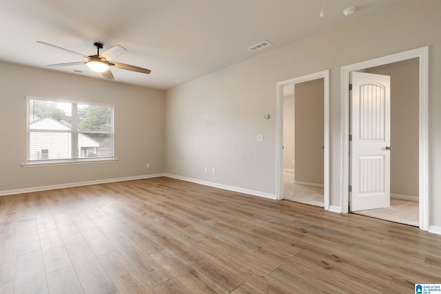 empty room with ceiling fan and light hardwood / wood-style floors