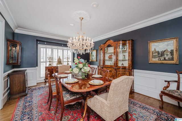 dining area with a chandelier, light hardwood / wood-style flooring, and ornamental molding