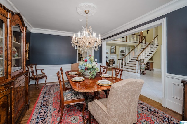 dining space featuring a notable chandelier, crown molding, and hardwood / wood-style floors