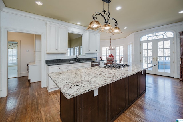 kitchen with appliances with stainless steel finishes, a chandelier, sink, french doors, and pendant lighting