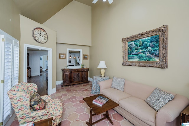 living room with ceiling fan and a towering ceiling