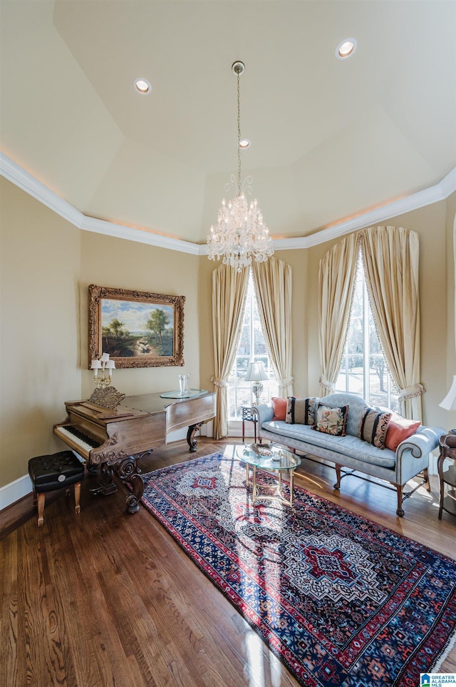 living room featuring crown molding, vaulted ceiling, hardwood / wood-style flooring, a tray ceiling, and a chandelier