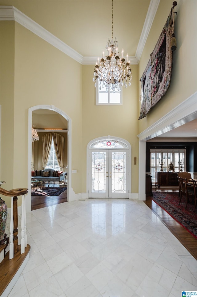 entryway featuring crown molding, plenty of natural light, and french doors