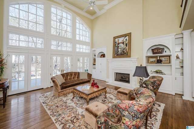 living room with ornamental molding, a healthy amount of sunlight, a high ceiling, and french doors