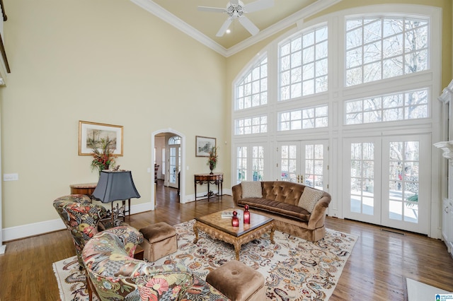 living room with french doors, a high ceiling, crown molding, and dark hardwood / wood-style flooring