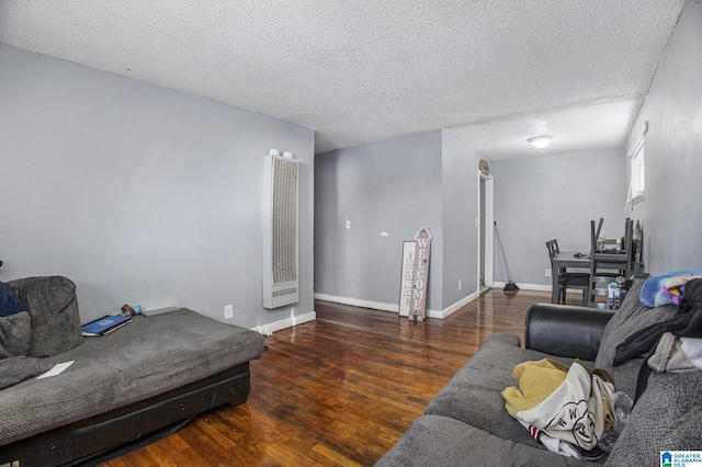 living room with dark hardwood / wood-style floors and a textured ceiling