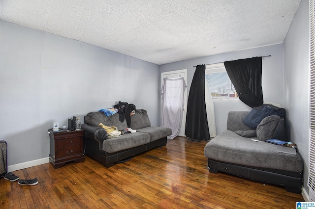 living room with dark wood-type flooring and a textured ceiling